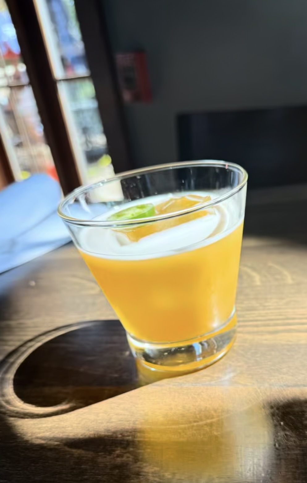 Orange cocktail served in a rocks glass