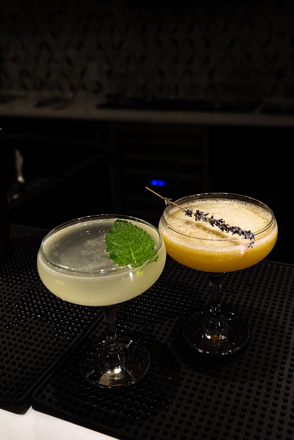 Two coupe cocktails on the bar
