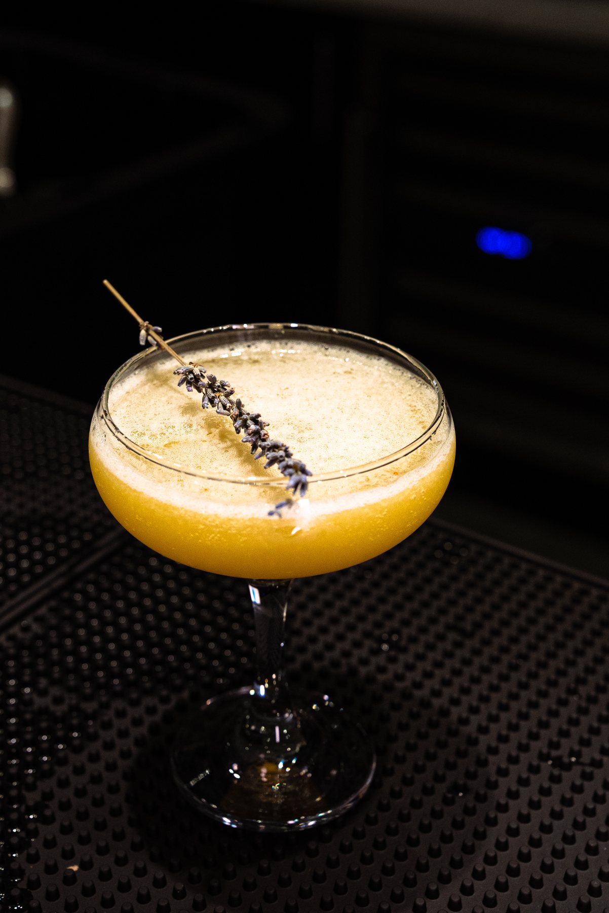 Golden coupe cocktail with lavender garnish